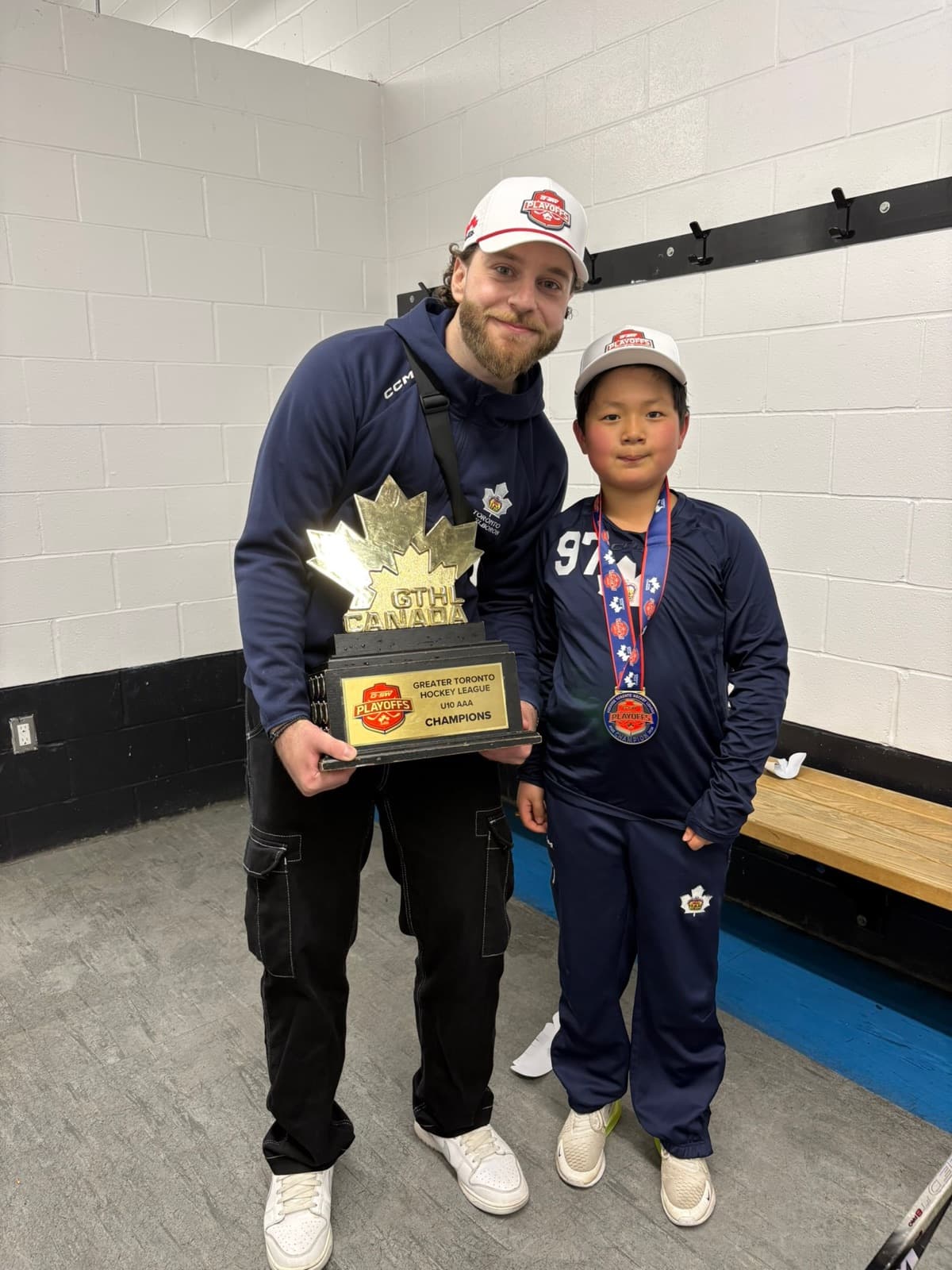 Michael and a young athlete celebrating a GTHL championship